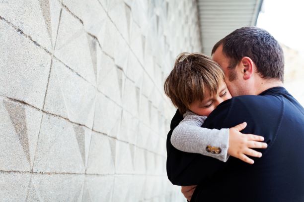 father hugging his sleeping son